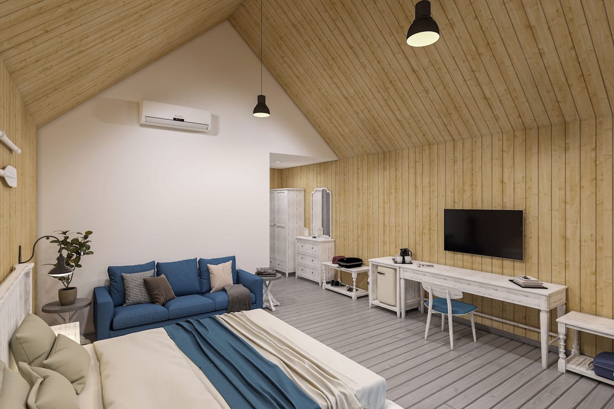 Een moderne, goed verlichte kamer met een houten plafond, een bed, een slaapbank, een bureau en een televisie.