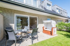 Een modern appartement met een patio, een eettafel en een lounge stoel.