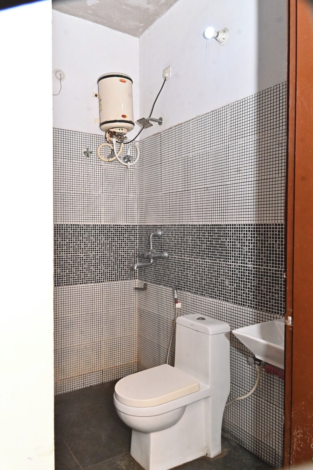 Un baño pequeño con inodoro, lavamanos y ducha.