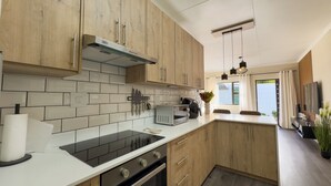Une cuisine moderne avec des meubles en bois, un four encastré et un four à micro-ondes.