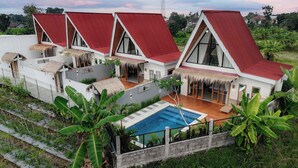 A modern villa with a swimming pool, large windows, and a red roof. - Villa Norte (Ngaglik)