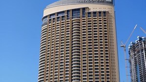 Ein hohes, zylindrisches Hotel mit geschwungener Fassade und zahlreichen Balkonen.