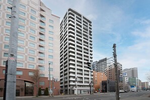 A tall, modern building with a checkered facade and multiple balconies. - PRALINE (Sapporo)