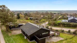 A modern two-story house with a sloped roof, surrounded by a well-maintained lawn and a few trees. - "Lenya" - 300m to the fjord by Interhome (Struer)