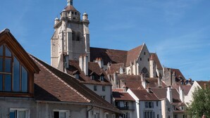Um edifício histórico com uma torre imponente e várias chaminés.