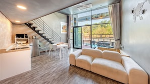 A modern interior with a kitchen, dining area, and a sofa.