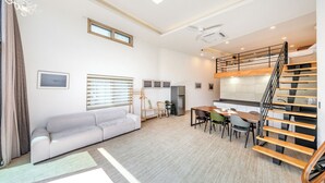 A compact living space with a bunk bed, a sofa, a dining table, and a kitchenette. - Gangneung Awesome Pension (Gangneung)