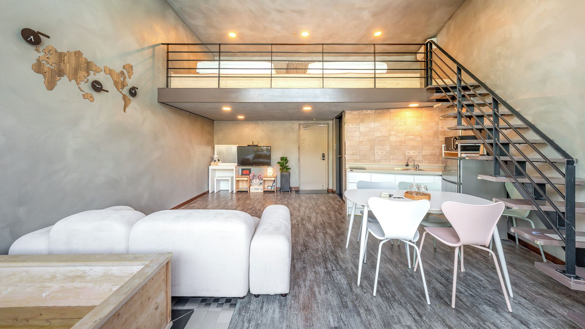 A modern interior with a loft bedroom, a dining area, and a kitchen.