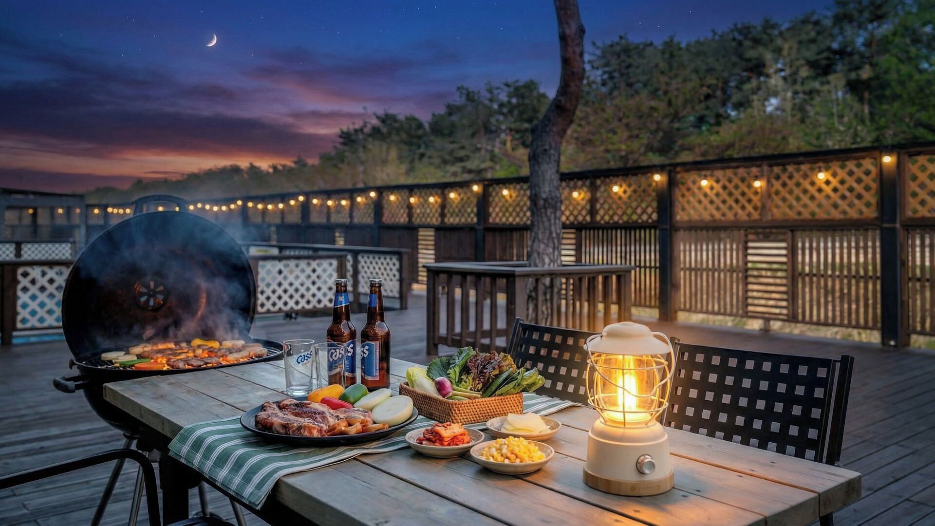 Un espacio de comedor al aire libre con una parrilla, mesa, sillas y un farol.