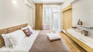 A hotel room with a bed, a wooden headboard, a bedside table, a wardrobe, and a window with curtains. - Stay Inn on Aram street (Yerevan)