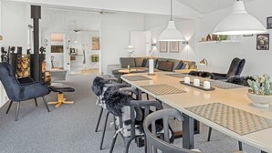 A modern interior with a dining area, a sofa, and a fireplace.