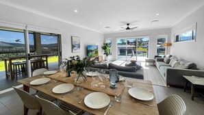 Una sala de estar moderna con comedor, ventanas amplias y vistas al exterior.