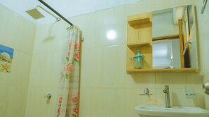 A bathroom with a toilet, shower, sink, and a mirror above the sink. - Perla Negra House Hostel (Cartagena)