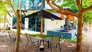 A modern outdoor pool area with a hot tub, lounge chairs, and umbrellas. - Perla Negra House Hostel (Cartagena)
