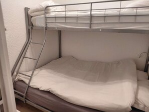 A bunk bed with a ladder, white bedding, and a wooden floor. - Studio rénové grand confort 3 étoiles - Résidence Les Crêtets (Les Rousses)