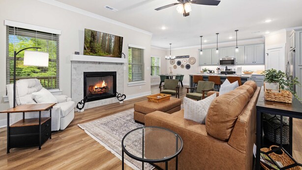 A modern living room with a fireplace, sofa, coffee table, and dining area. - Discoverer - Ozark Mountain Retreat - Pets Allowed (Bella Vista)