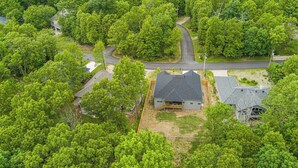 An aerial view of a residential area with houses surrounded by dense greenery. - Discoverer - Ozark Mountain Retreat - Pets Allowed (Bella Vista)