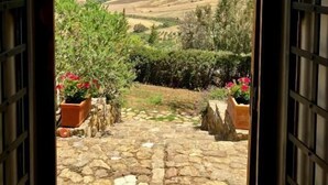 An open doorway leading to a stone-paved courtyard with a mountainous landscape in the background. - Le Case di Cardellino - AgriSpa (Sclafani Bagni)