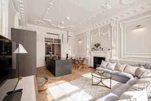 A spacious living room with a fireplace, a dining area, and a kitchen.