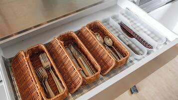 A drawer with wicker baskets containing cutlery.