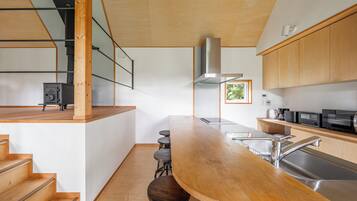 A modern kitchen with a wooden bar, stainless steel appliances, and a built-in stove.