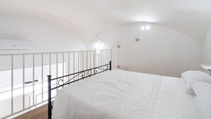 A bedroom with a white bed, a black metal headboard, a white railing, and a view of the outside. - Mifra n 1 in Bari With 1 Bedrooms and 1 Bathrooms (Bari)