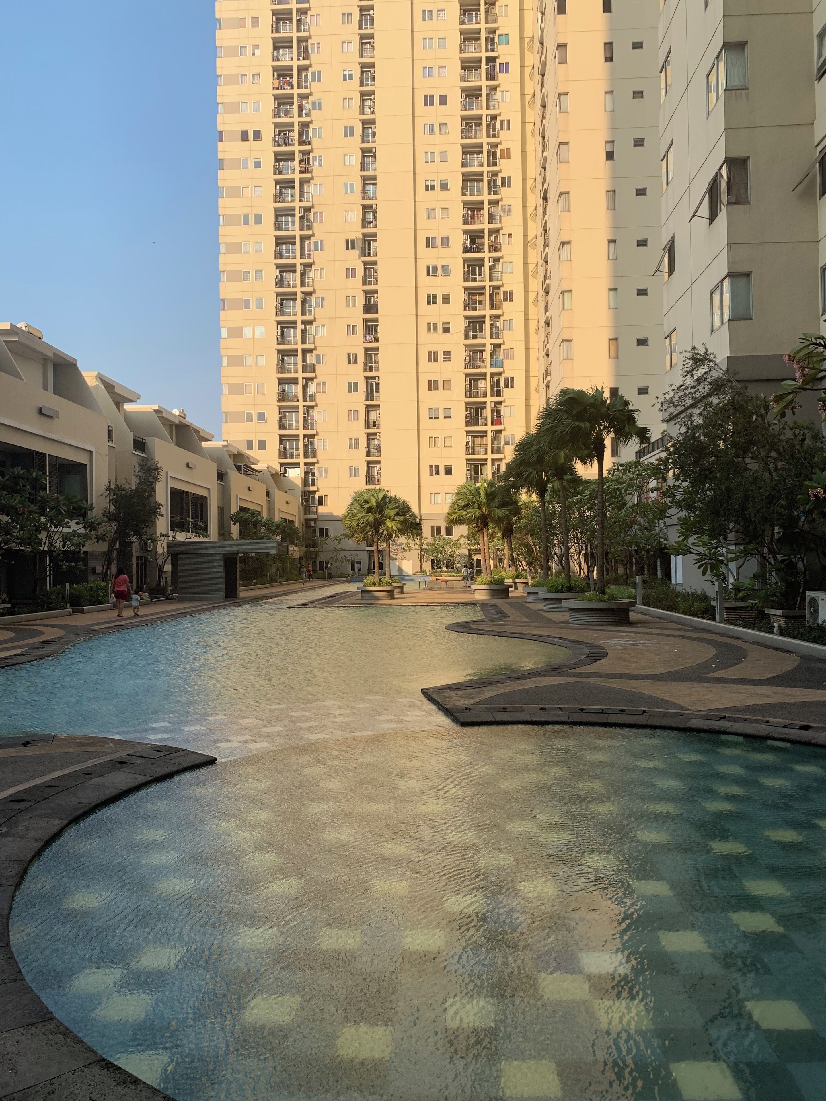 Un barrio residencial con piscina, edificios de gran altura y zonas verdes cuidadas.