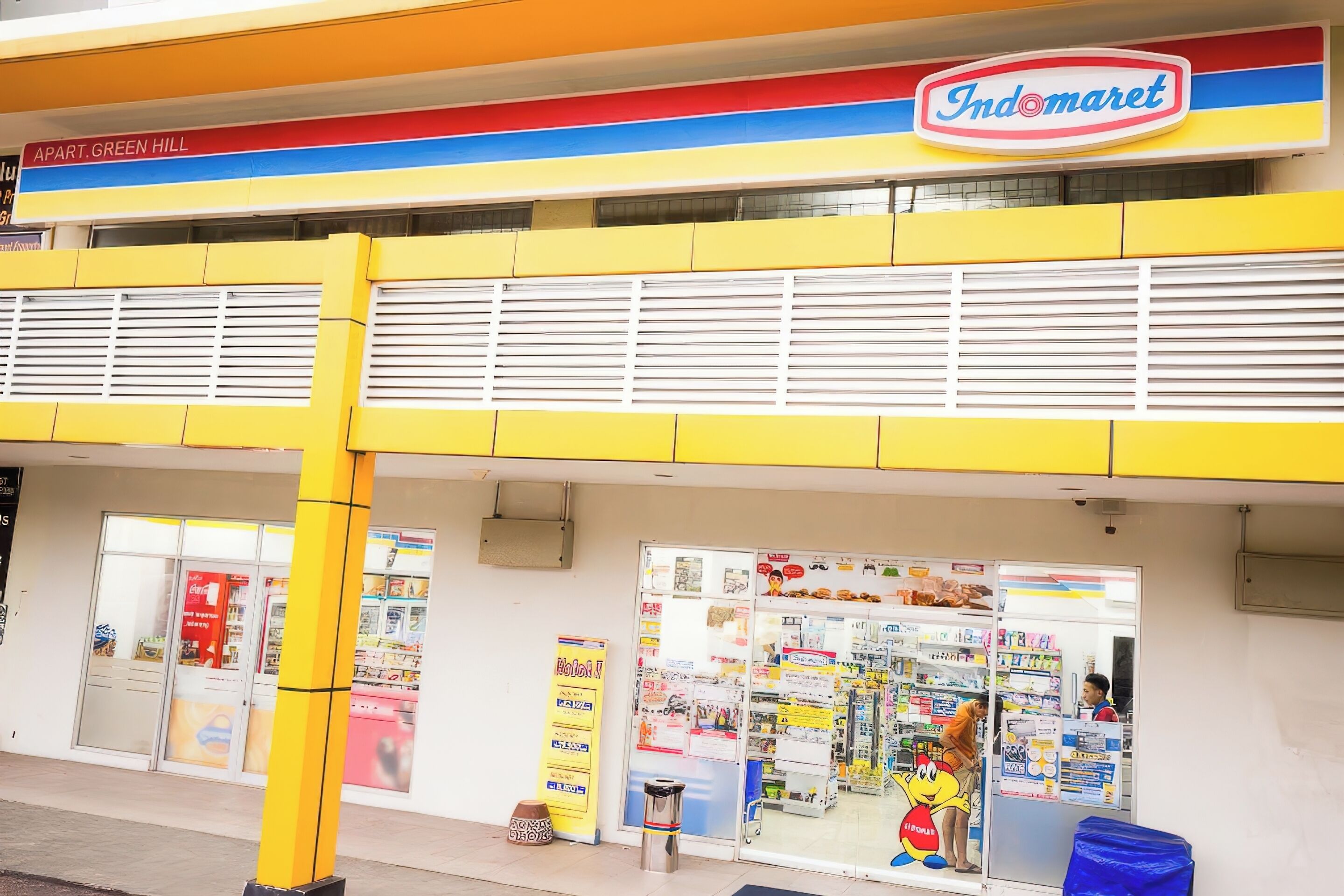 Fachada com um letreiro colorido, entrada visível e vitrine com diversos artigos.