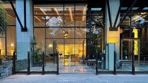 A hotel entrance with a glass facade, a reception desk, and a seating area visible inside. - Sudirman Suites Apartment Jakarta (Jakarta)