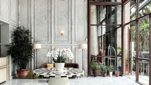 A spacious lobby with a high ceiling, large windows, and a central round table with potted plants. - Sudirman Suites Apartment Jakarta (Jakarta)
