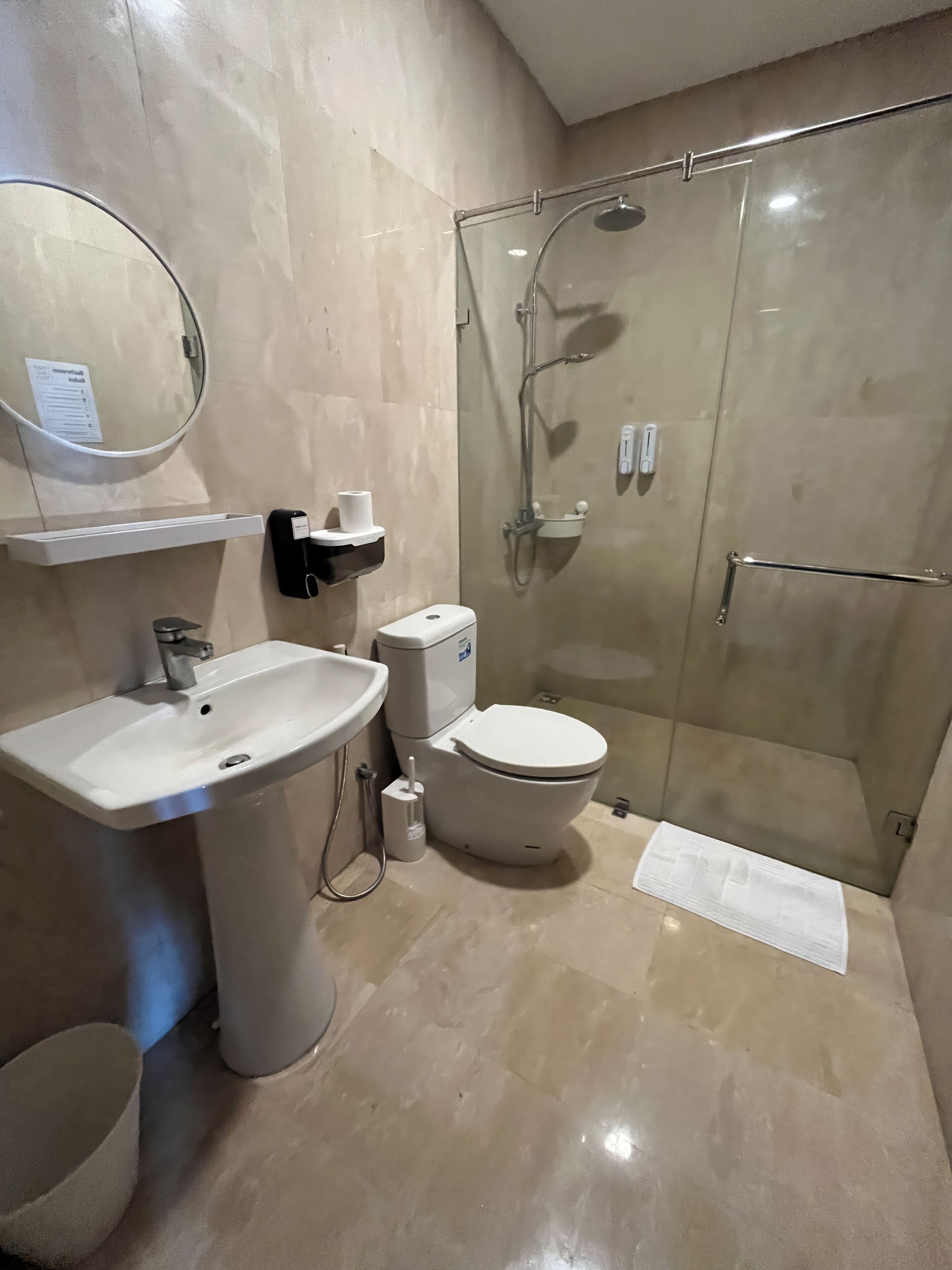Une salle de bain moderne avec un lavabo, des toilettes et une douche à parois de verre.
