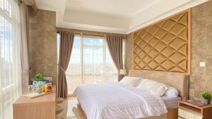 Une chambre d’hôtel moderne avec un grand lit, un bureau en bois et une vue sur la ville.