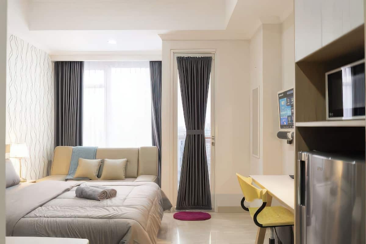 Une chambre d’hôtel équipée d’un lit, d’un bureau, d’une chaise et d’un réfrigérateur.