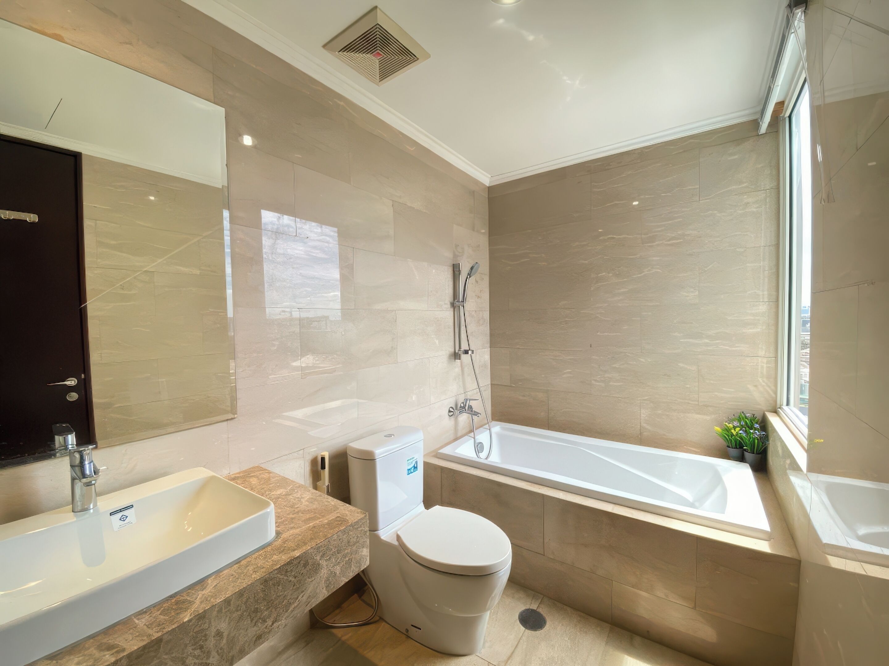 A modern bathroom with a bathtub, toilet, and sink.