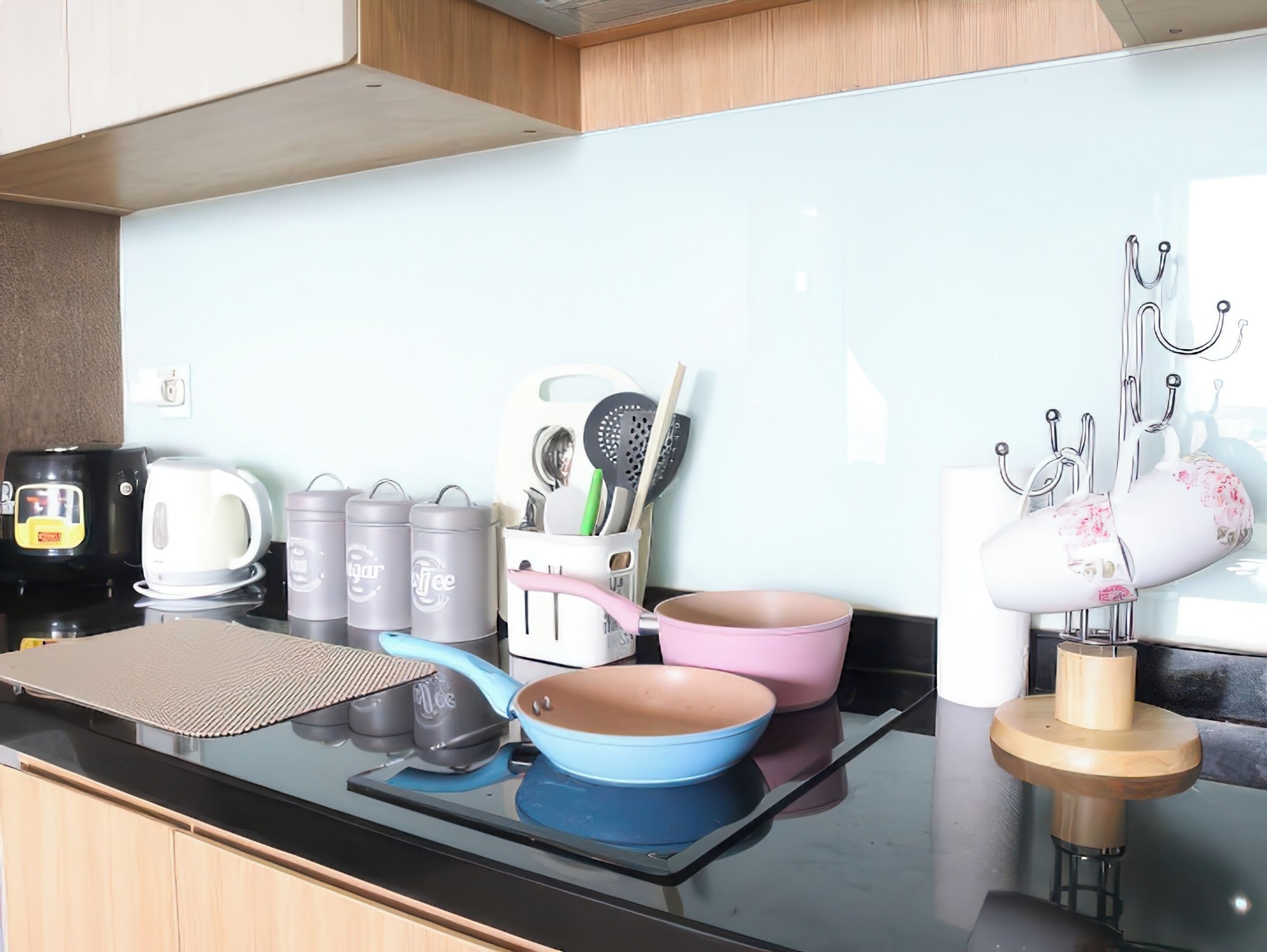 Una cocina moderna con encimera negra, electrodomésticos de acero inoxidable y una variedad de utensilios y utensilios de cocina.