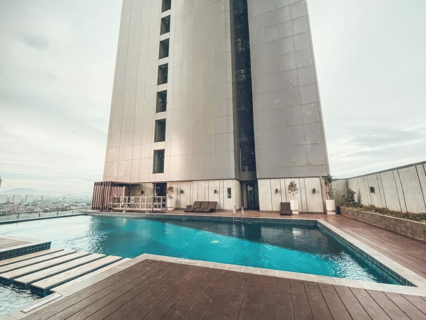 Un edificio moderno con una zona de piscina en la azotea.