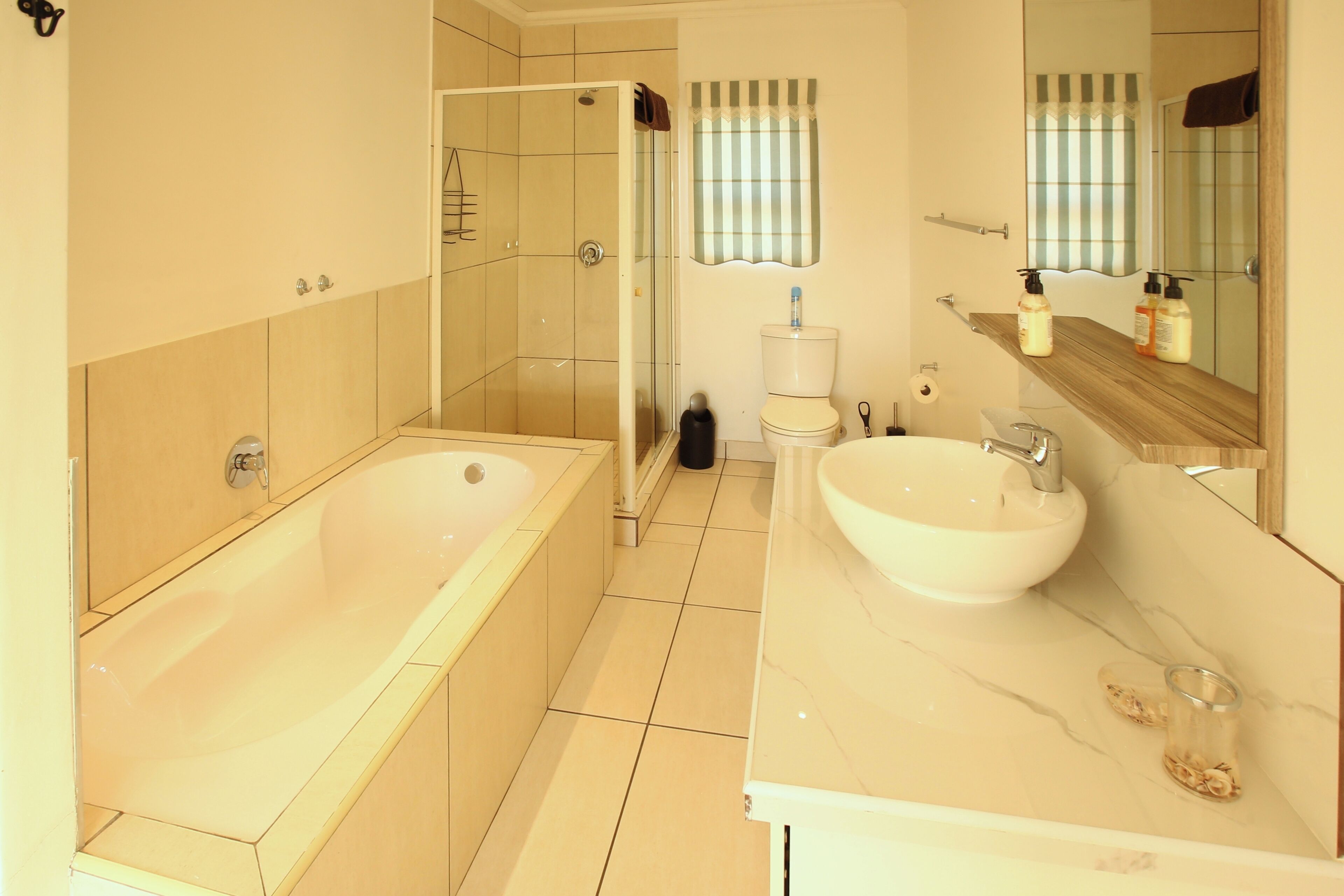 A modern bathroom with a bathtub, a sink, and a shower.