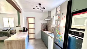 A modern kitchen with a wooden island, a built-in oven, and a dishwasher. - Green cocoon with private swimming pool (Cunèges)