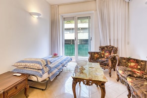 Relax in this serene bedroom with a comfortable bed, nightstand, and armchairs.