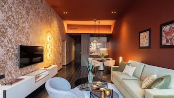 Una sala de estar moderna con un televisor de pantalla plana, un sofá, una mesa de centro y un comedor con una mesa redonda y sillas.