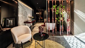 A modern interior with a sofa, a small table, and a decorative plant. - Palazzo Rota Luxury Apartments (Venice)