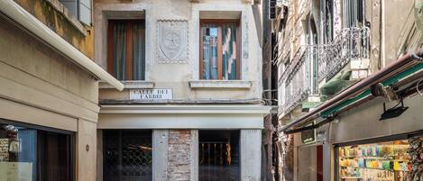 Une rue étroite, avec un magasin sur le côté droit et un bâtiment portant une enseigne indiquant « Calle dei Fabbr ».