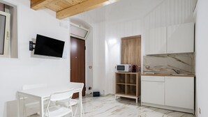 Une cuisine de taille réduite, avec des meubles blancs, un four à micro-ondes et un évier.