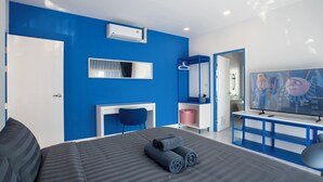 Een moderne hotelkamer met een groot bed, een televisie, een bureau en een badkamer zichtbaar door een geopende deur.