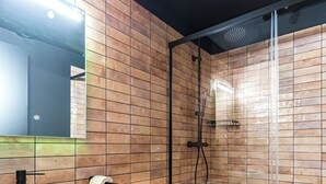 A modern bathroom with a white sink, toilet, and glass shower enclosure. - Apartamentos HEY U (Murcia)