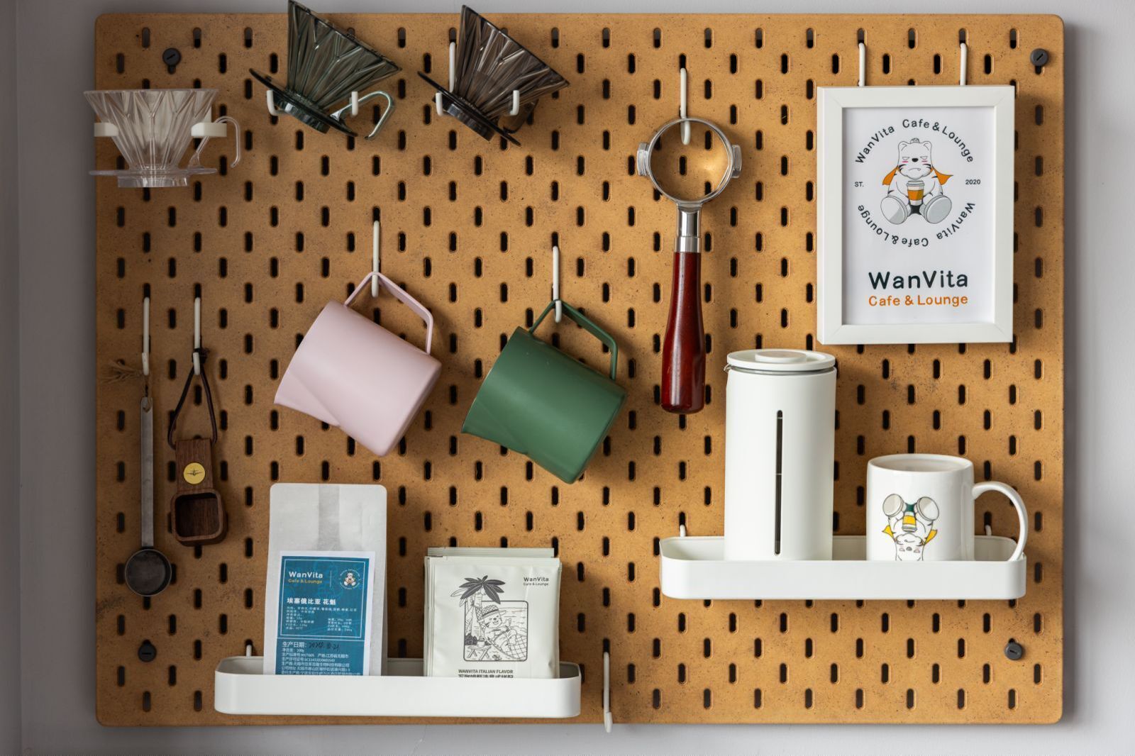 A pegboard wall with various kitchen items and a framed certificate.