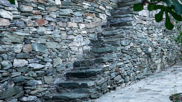A stone staircase leading up a stone wall, surrounded by greenery. - Secluded Cottage Guesthouse in the Mountains (Volos)