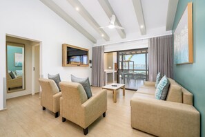Een moderne woonkamer met een zithoek, een flatscreen televisie en een balkon met uitzicht.