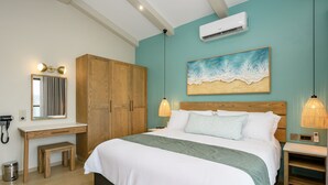 Un dormitorio con cama, mesitas de noche, armario, escritorio y aire acondicionado.