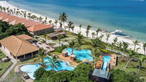 Un resort con piscina grande, playa y vista al océano.